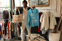 a man standing in front of a rack of clothes