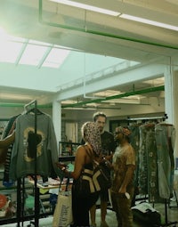 a group of people looking at clothes in a warehouse